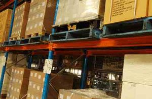 Assorted brown boxes stacked onto pallets and racks in a warehouse